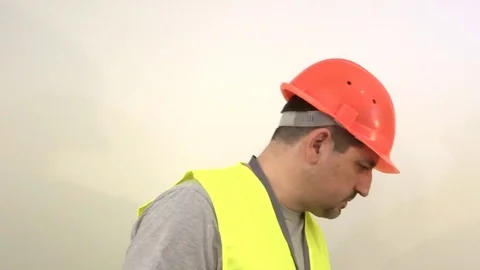 Worker in a protective helmet raises and lowers his head Stock Footage 93192248