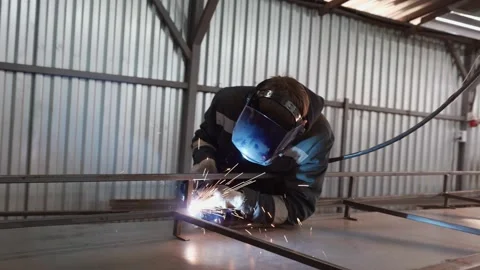 A worker in a protective mask uses a gas welding torch to connect the seam of a Stock-Footage 166077986