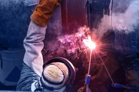 Worker with protective mask welding bore pile metal casing at a construction 写真素材
