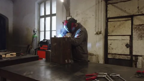 A worker in a protective mask welds metal parts Vídeo Stock 225769882