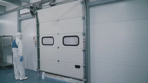 A worker in a protective suit opens the warehouse Stock Footage 145694708