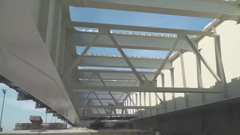 The worker in a protective suit paints with white paint building constructions Video stock 316590338