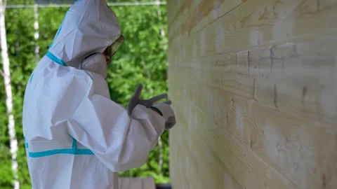 Worker in Protective Suit Preparing for Chemical Treatment of Wooden Wall.. Stock Footage 311762206