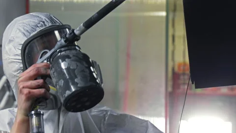 Worker in protective suit spraying paint on metal surface, Industrial painting Stock Footage 309234605