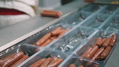 Worker in protective uniform pack and stack sausages in plastic packaging 스톡 동영상 244322661