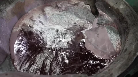Worker prying a rough cast aluminum part loose from a sand mold at a foundry Stock Footage 343370777