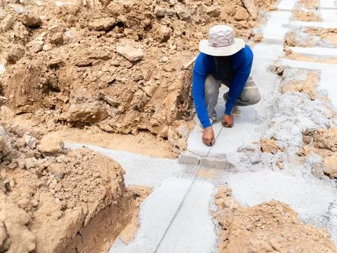 The worker is pulling a chalk line to mark the area for placing the beam. Stock-Fotos
