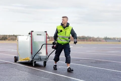 Worker Pulling Machine On Cart At Airport Runway Stock Photos