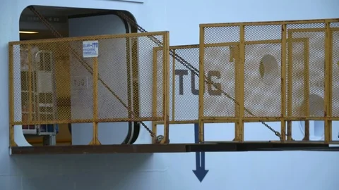 Worker pulling the pallet cage full of tourist luggages to unload at Terminal 25 Stock Footage 116417497