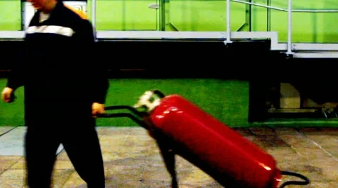 Worker Pulls Fire Extinguisher And LooksBack Stockbeeldmateriaal 10804680