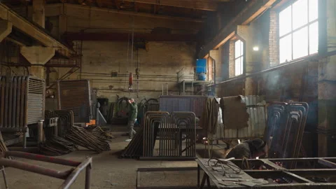 Worker pulls goat crane hook walking along plant workshop Vídeo Stock 243306235