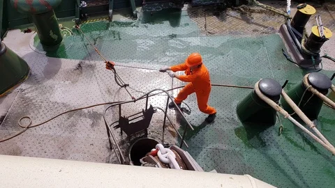 Worker pulls grey hosepipe and man cleans ship deck Stock Footage 113192348