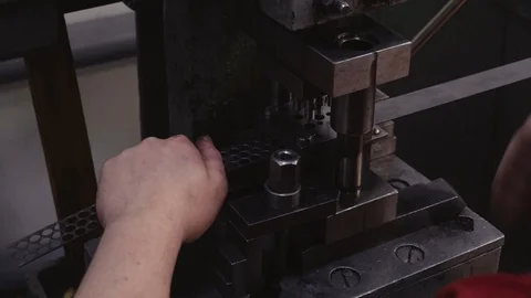 A worker pulls a metal blank and the machine stamps the parts. Close-up Stock Footage 115907460