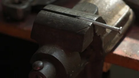 Worker pulls a nail out of a vice, slow motion, close up Видео 95829423