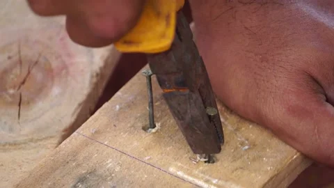 The worker pulls a nail out of the wooden Stock Footage 151471306