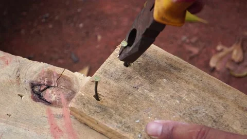 The worker pulls a nail out of the wooden Stock Footage 151471343