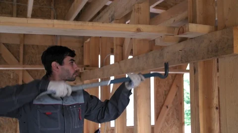 The worker pulls out mistakenly hammered nail. Crowbar pulled out the nail. The 库存影片 103311636