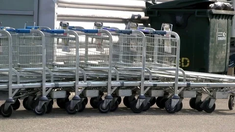 Worker pushes the row of shopping carts (shopping trolley) Stock Footage 91322288