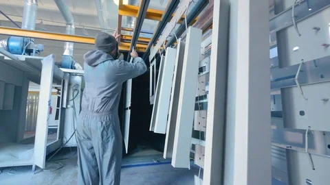 Worker put painted elements to the storage. Industrial painting of metal parts Stock Footage 73802598