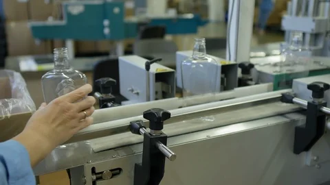 Worker put plastic bottles on a conveyor belt. Bottle transfer on conveyor belt  Stock Footage 128454694