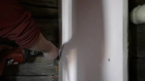 Worker put a rigips on a wall panel in wood, with screws using a drill Stock Footage 59682034