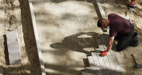 Worker put tiles in new pavement pedestrian way -- view from above Stock Footage 89910008