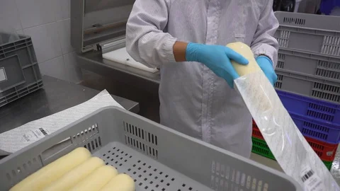 A worker puts cheese in the package to prepare to seal Stock Footage 129928161