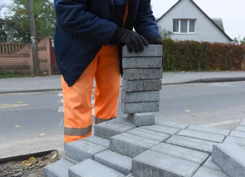 A worker puts concrete bricks on a pallet. Stock Photos
