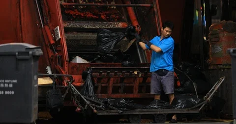Worker puts garbage into rubbish collection truck. City waste disposal Stock Footage 102590249