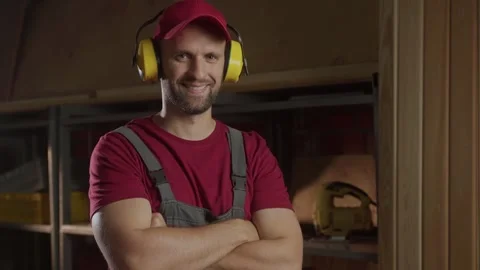 A worker puts on hearing protection and gets ready to start a woodworking Stock-Footage 281673472