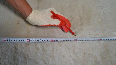 The worker puts a mark and draws a cutting line on the block. Installation of Stock Photos