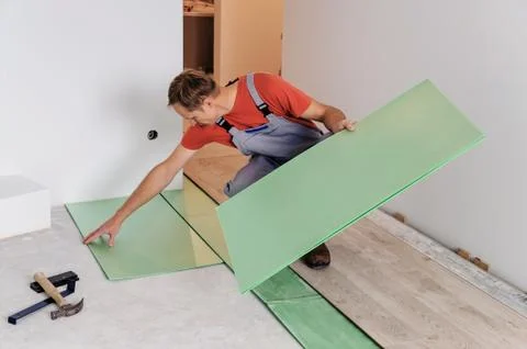 Worker puts the pieces underlaymen Stock Photos