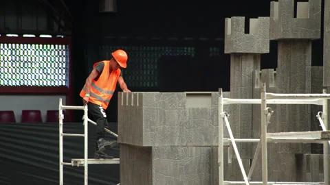 A worker puts in place a piece of a castle stand. Stock Footage 132445492