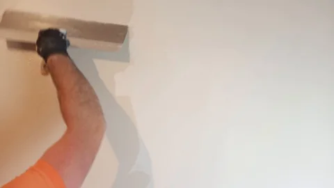 The worker puts the putty on the walls. It's equal, it's plastering Stock Footage 124226713