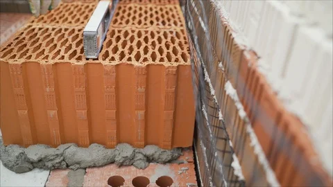 Worker puts a red ceramic block. Stock Footage 116650919