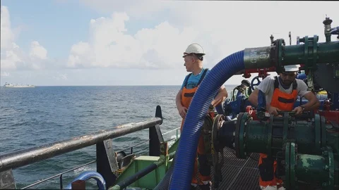 Worker puts rope on hosepipe and colleague unscrews valve Stock Footage 118358116