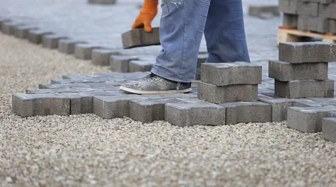 Worker puts sidewalk tile Stock Footage 60987198