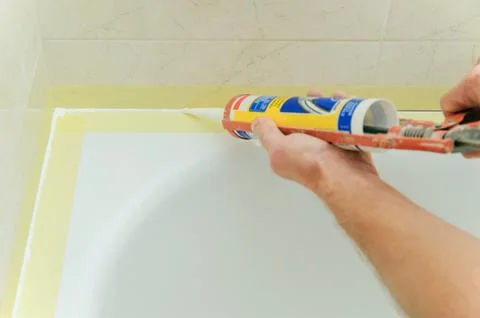 Worker puts silicone sealant. Stock Photos