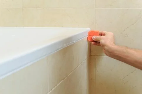 Worker puts silicone sealant. Stock Photos