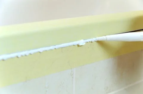Worker puts silicone sealant. Stock Photos