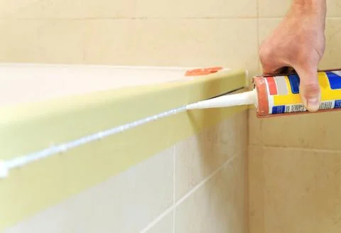 Worker puts silicone sealant. Stock Photos