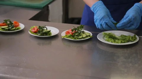 A worker puts slices of vegetables on plate closeup Stock Footage 64993948