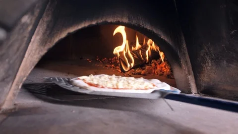 Worker puts spatula into oven and leaves pizza dough to bake Stock Footage 126951972