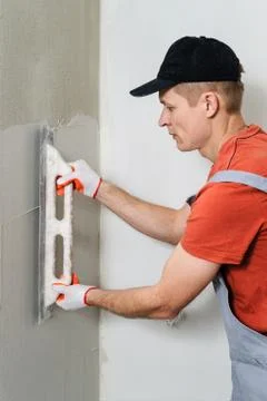 The worker puts the stucco on the wall Stock Photos