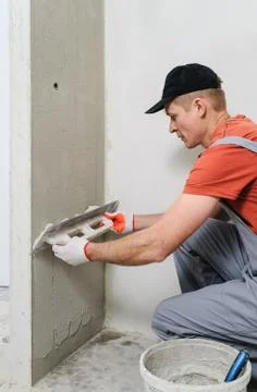 The worker puts the stucco on the wall Stock Photos