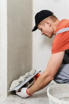 The worker puts the stucco on the wall Stock Photos