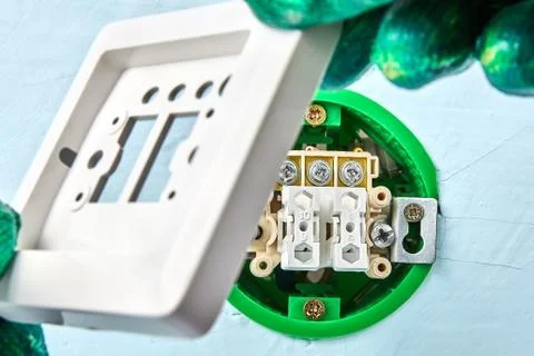 Worker puts top on light switch. Stock Photos