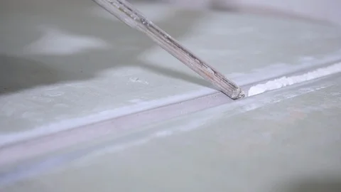 Worker puts white sealant into cut groove in plasterboard Video stock 108583146