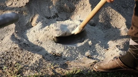 Worker is putting cement with a shovel into the cement mixer Stock Footage 75773252