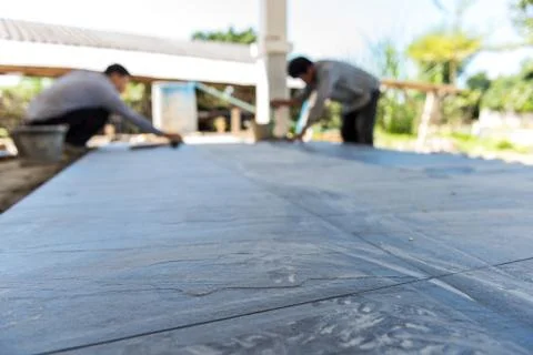 Worker putting ceramist tile on the floor. Professional ceramist is laying ce Stock Photos